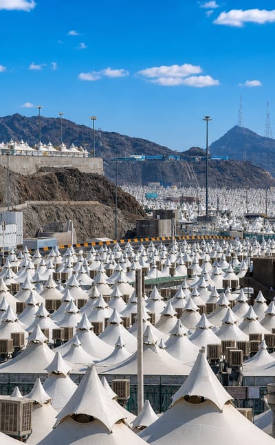 Rows of white air-conditioned pilgrim tents beneath the hills of Mina near Makkah