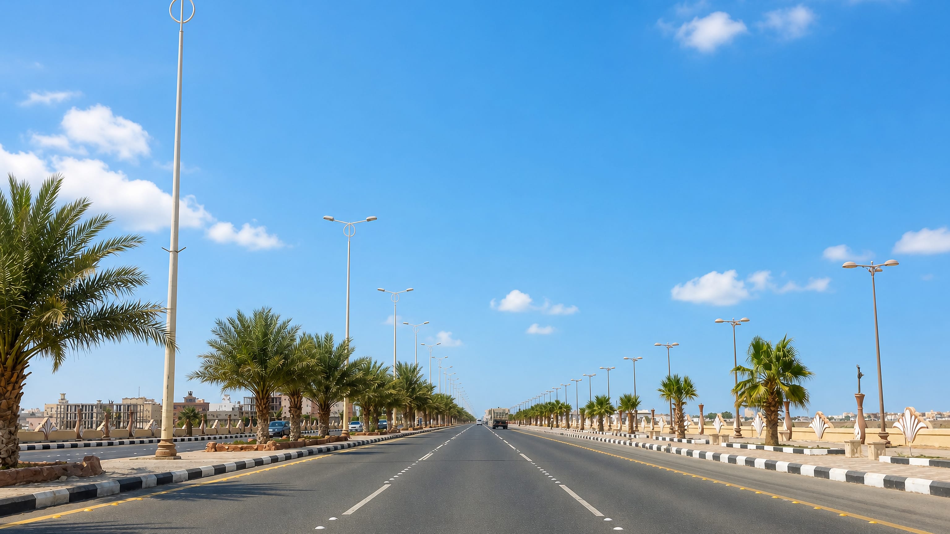 Palm-lined divided highway running through low-rise Rabigh on Saudi Arabia's Red Sea coast.