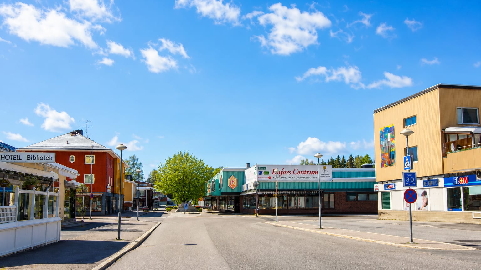 Hofors Centrum shops with a hotel, library and ELON store along the town centre street, Sweden.