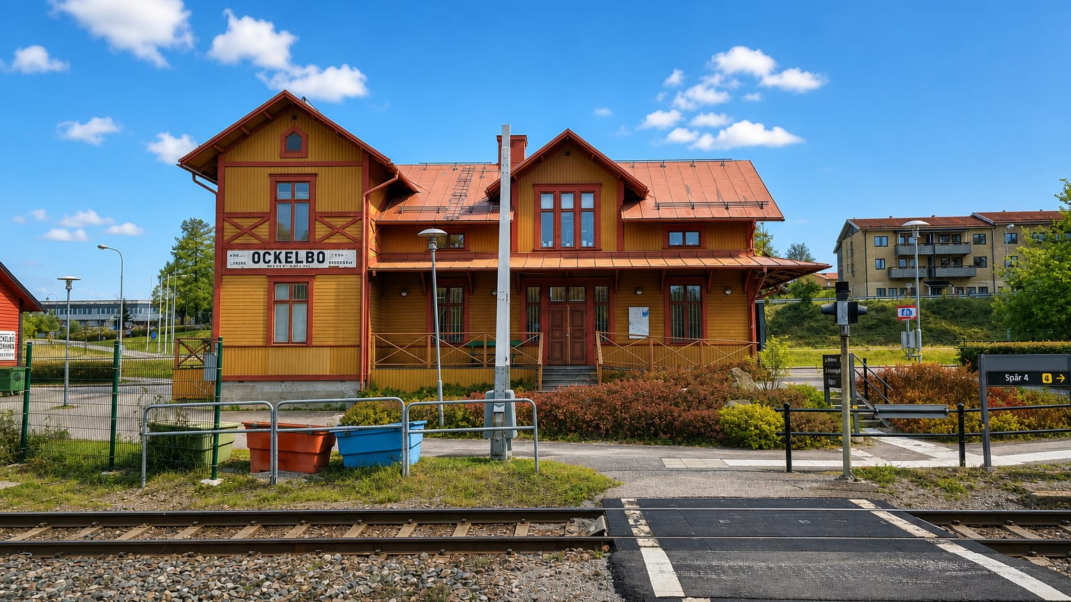 Historic yellow-and-red wooden railway station with a legible OCKELBO sign in Ockelbo, Sweden.