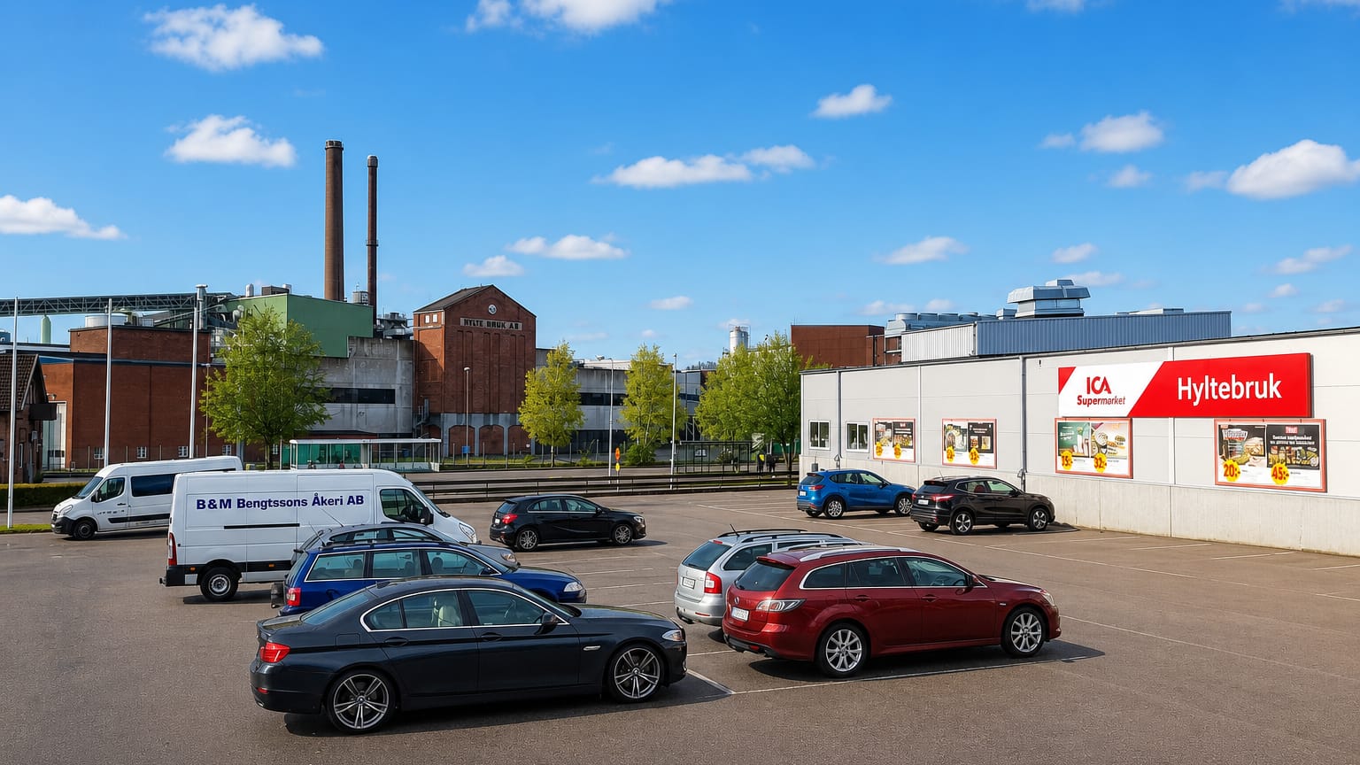 Car park by an ICA supermarket and the paper-mill chimneys of the industrial town of Hyltebruk, Halland.