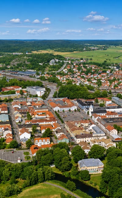 Aerial view of Kungsbacka's red-roofed town centre and winding river amid Halland farmland, Sweden.