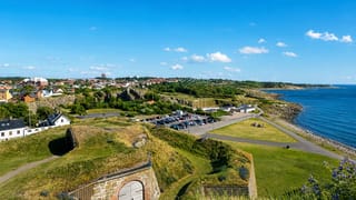 View from Varberg Fortress over its grassy ramparts toward the town and Kattegat coastline