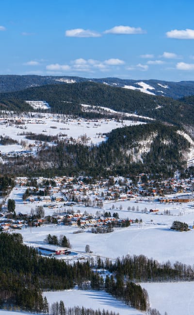 Aerial winter view of Hammarstrand village spread across a snowy river valley in Jämtland.