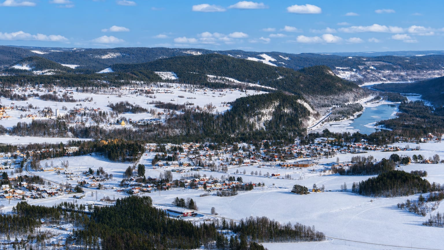 Aerial winter view of Hammarstrand village spread across a snowy river valley in Jämtland.