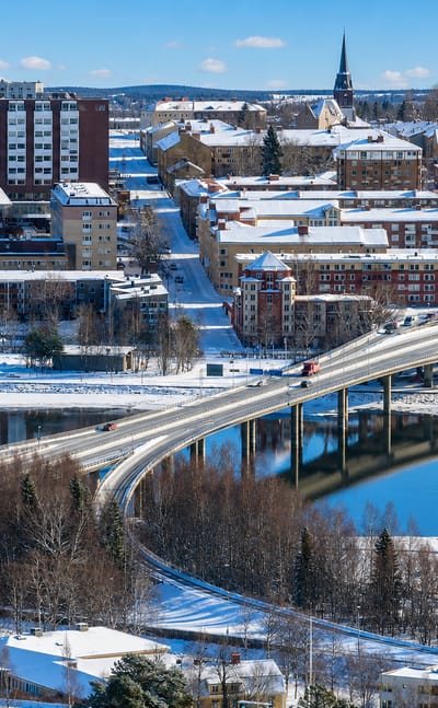 Snow-covered Ostersund with a long bridge over frozen Lake Storsjon and the church spire in Sweden.