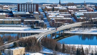 Snow-covered Ostersund with a long bridge over frozen Lake Storsjon and the church spire in Sweden.