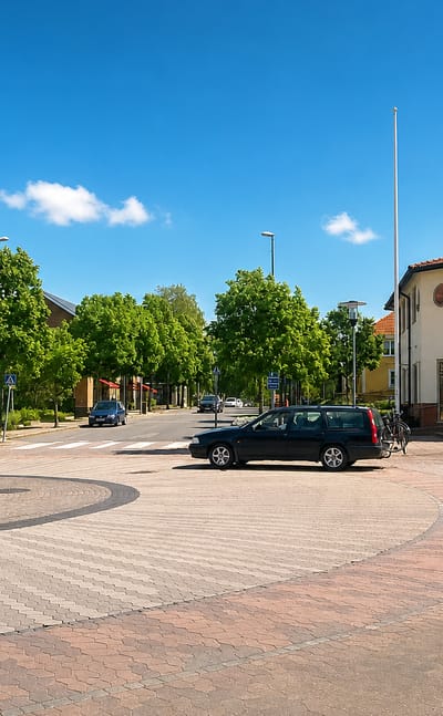 Brick-paved town square in Aneby, Sweden, fronting the Aneby Kommun municipal building under a blue sky