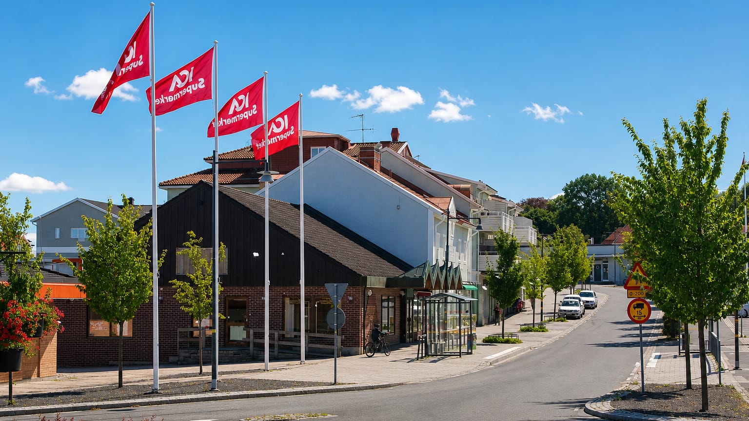 Central street in Habo lined with red ICA supermarket flags, brick buildings and a bus shelter in summer.