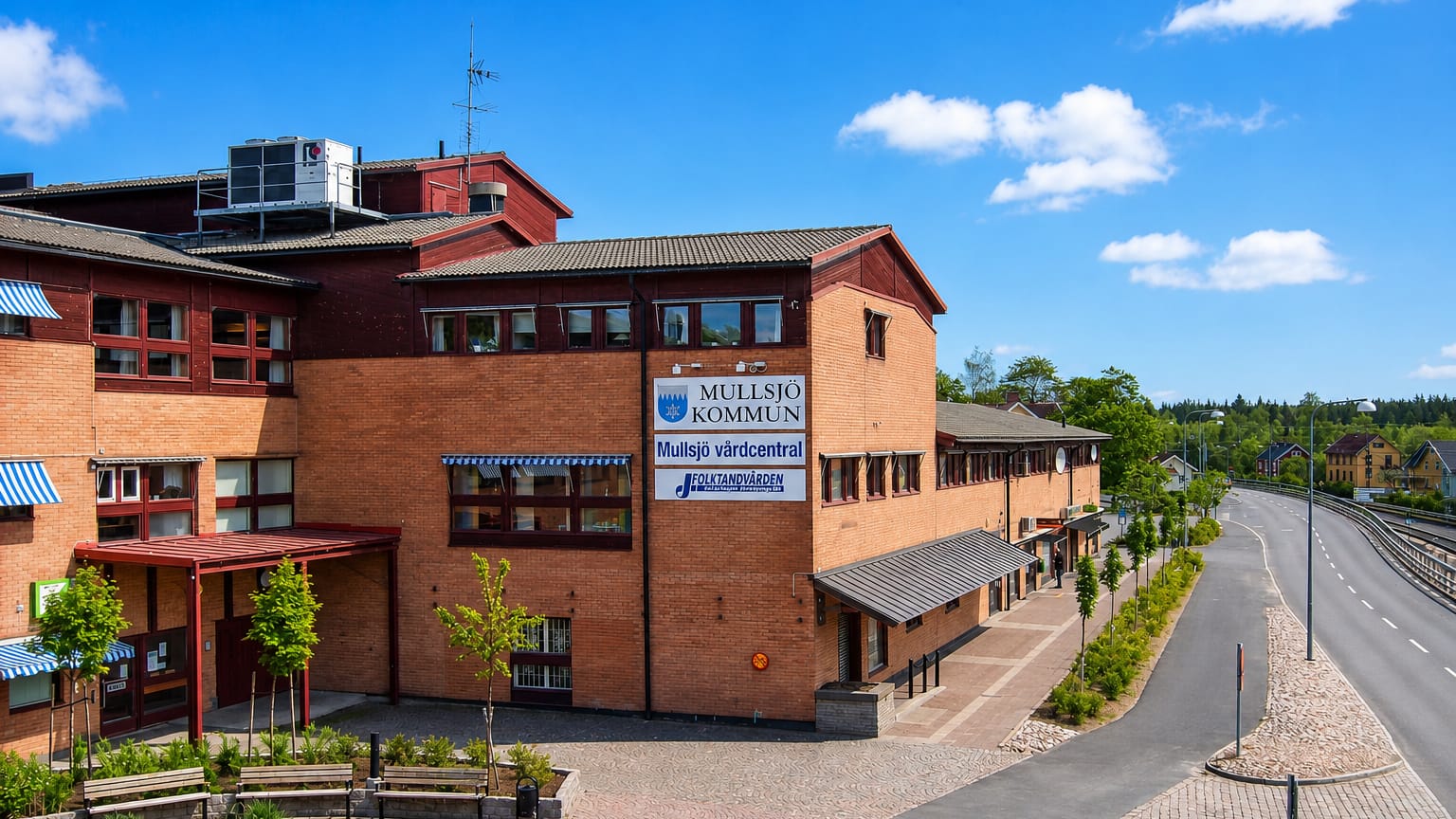 The red-brick Mullsjo Kommun municipal building and health centre on a paved square in Mullsjo, Sweden.