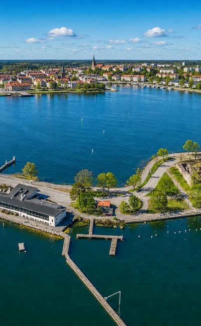 Aerial view of Västervik, Sweden, an archipelago town with a peninsula fortress ruin, church spires and marinas.