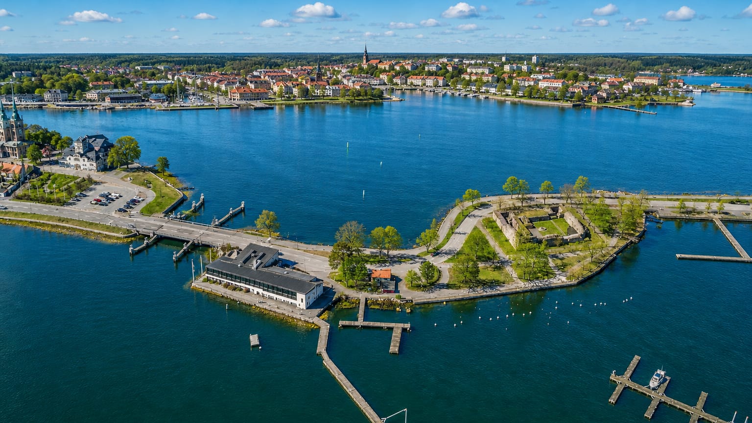 Aerial view of Västervik, Sweden, an archipelago town with a peninsula fortress ruin, church spires and marinas.