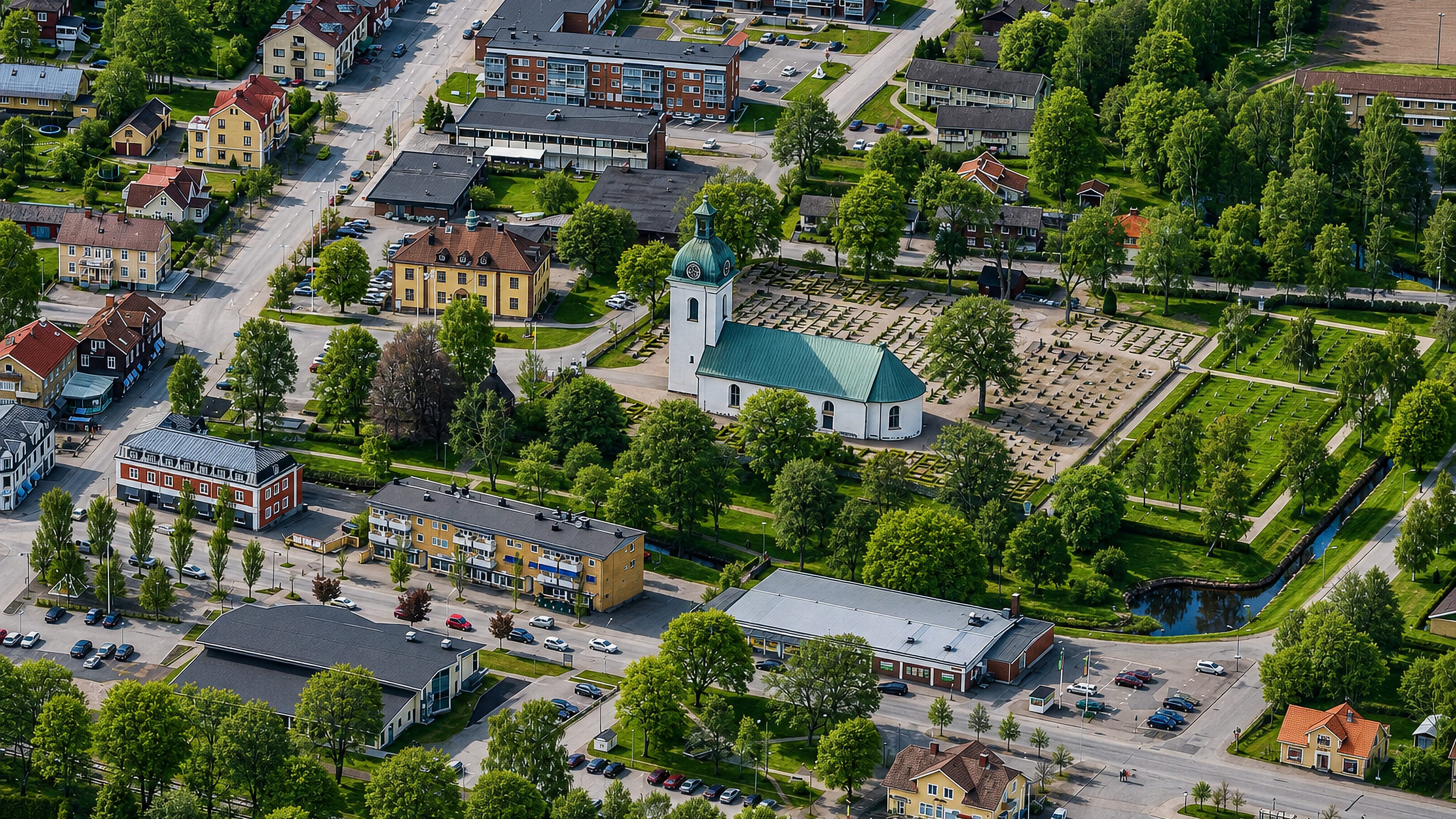 Aerial view of Asa, Sweden, centred on its green-domed church, main street and leafy town blocks
