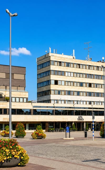 Ljungby's main square with the Hotel Terraza building, an SEB bank and flower planters in sunshine