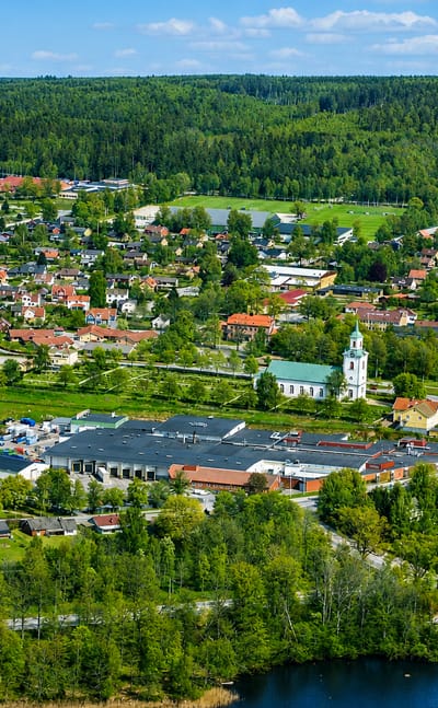 Aerial view of Tingsryd with its white church, lake and surrounding forest in Kronoberg, Sweden