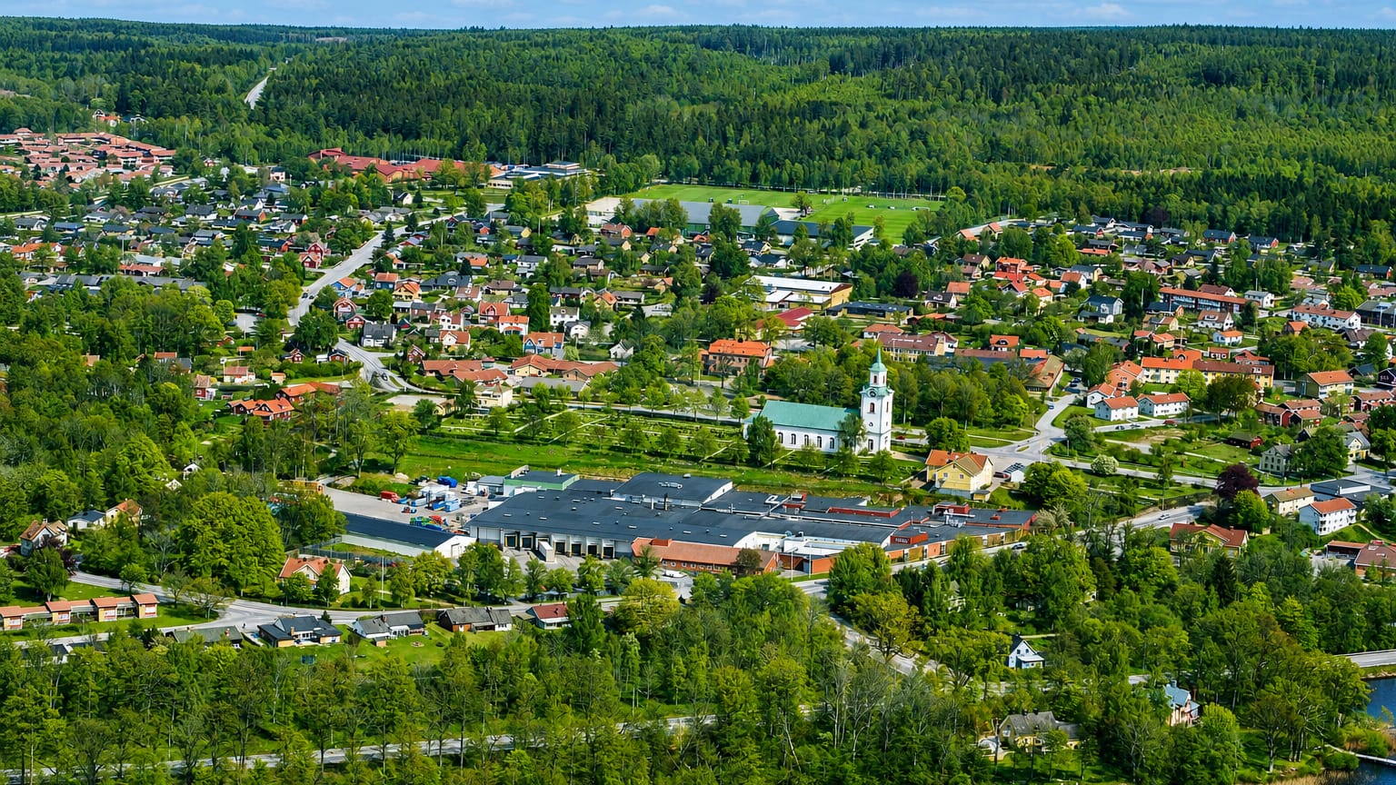 Aerial view of Tingsryd with its white church, lake and surrounding forest in Kronoberg, Sweden