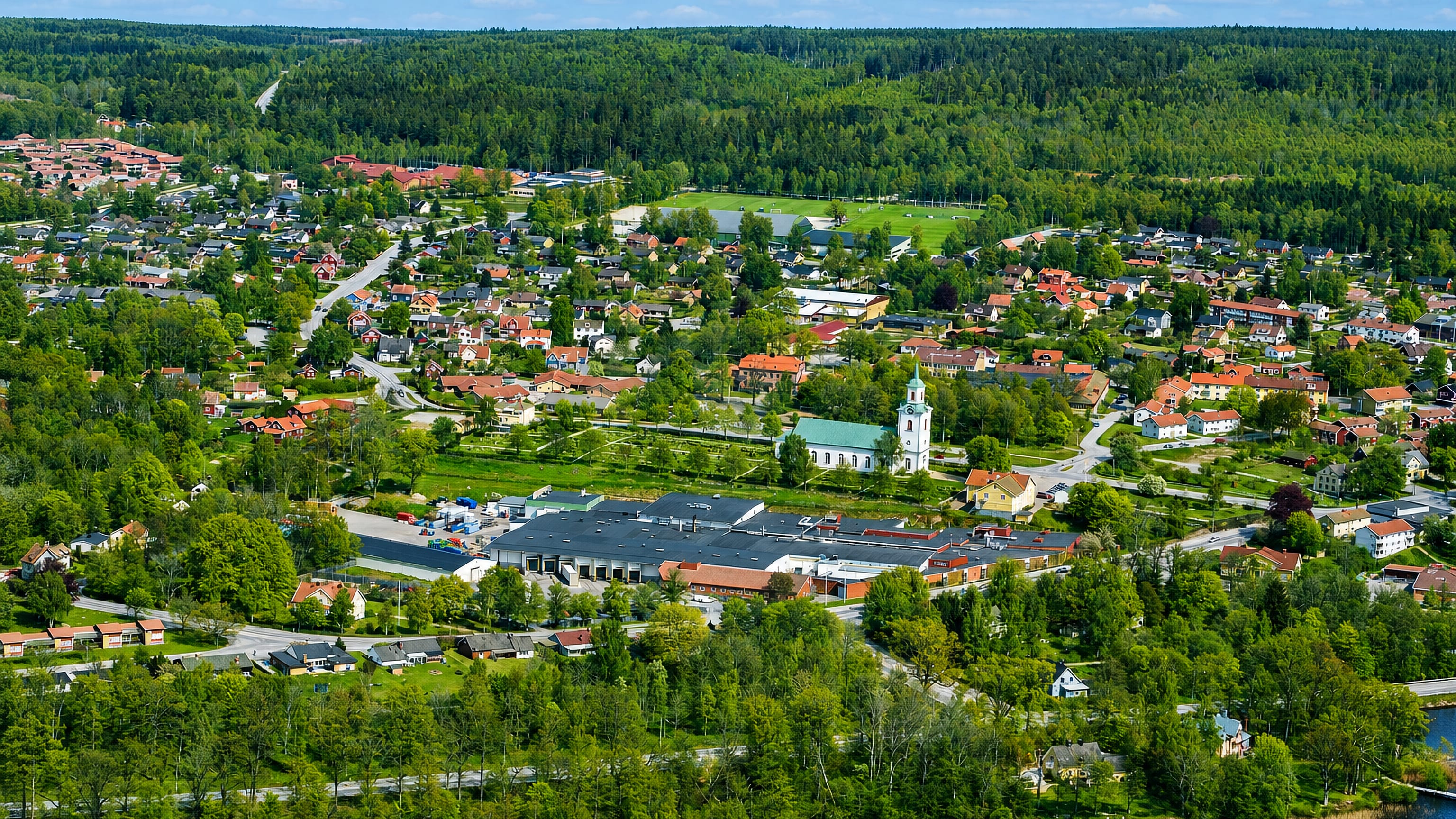 Aerial view of Tingsryd with its white church, lake and surrounding forest in Kronoberg, Sweden
