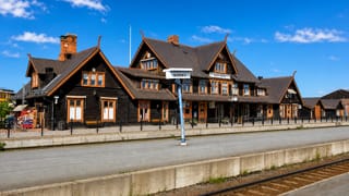 The ornate dark-timber Boden Central railway station under a blue sky in Boden, Sweden