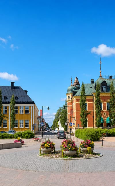 Haparanda town square, Sweden, with its ornate red-brick town hall, copper roof and clock tower beside a yellow building