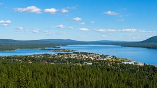 Jukkasjarvi village, Sweden, spread along a lakeshore amid vast Lapland forest with distant fells