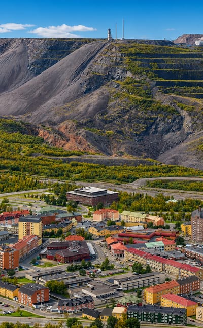 Kiruna, Sweden below its terraced iron-ore mine mountain with the mine headframe on the ridge