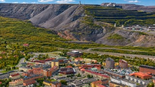 Kiruna, Sweden below its terraced iron-ore mine mountain with the mine headframe on the ridge