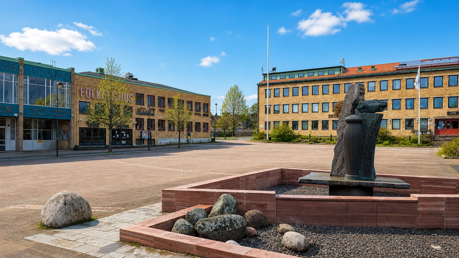Degerfors town square with the Folkets Hus building, yellow-brick offices and a bronze sculpture