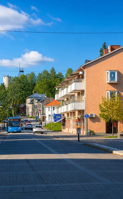 Central street in the mining town of Kopparberg with a mine headframe on the hillside beyond