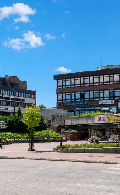 Central square in Finspang, Sweden, with the kommun building, Ostgota Enskilda Bank and shops under blue sky