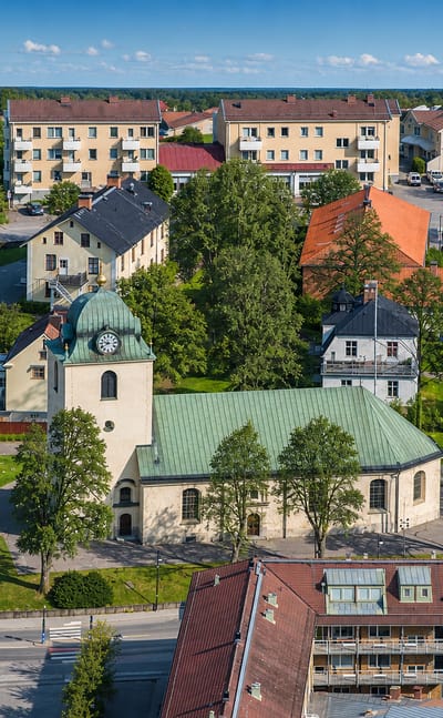 Aerial view of central Mjolby, Sweden, with the copper-roofed church and apartment blocks amid green parkland