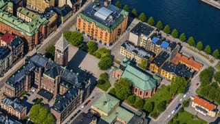 Aerial view over central Norrkoping, Sweden, showing riverside blocks with a church tower and domed church