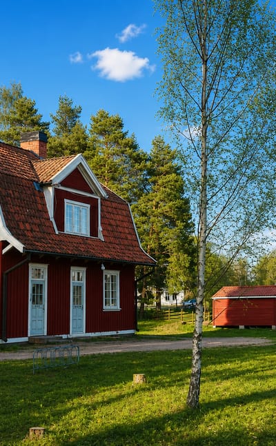 Österbymo's red wooden railway station, labelled Österbymo, with a semaphore signal and birch trees on grass.