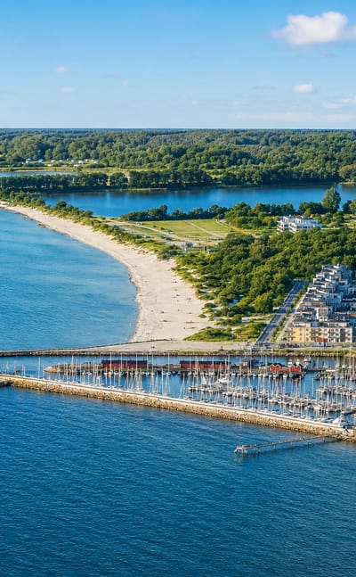 Coastal aerial of Lomma, Sweden, showing its sandy beach, marina and modern waterfront apartments