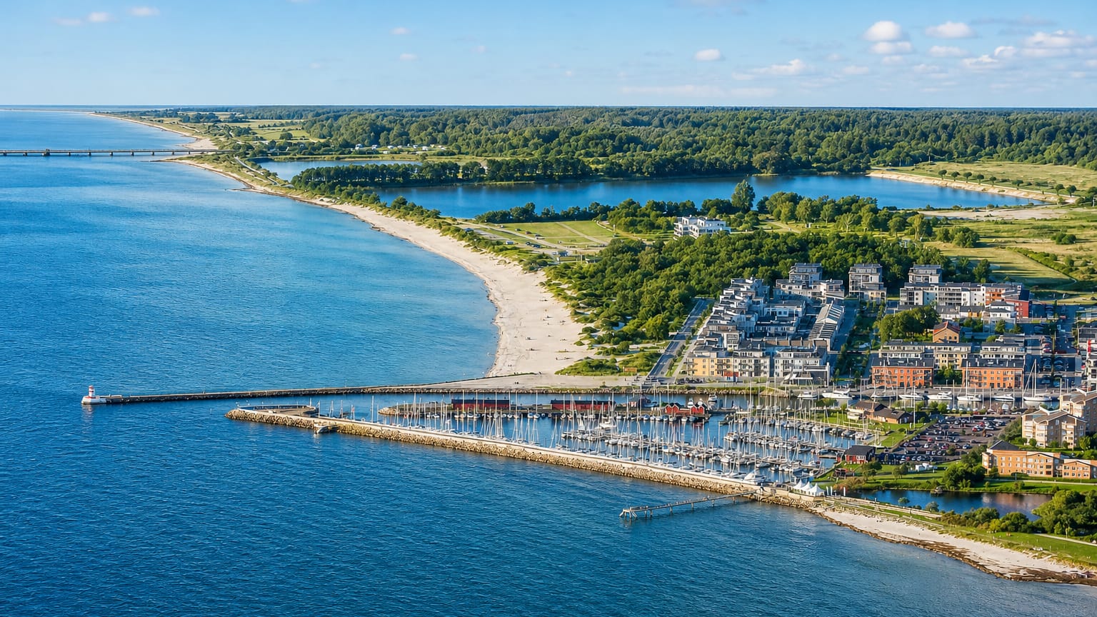 Coastal aerial of Lomma, Sweden, showing its sandy beach, marina and modern waterfront apartments