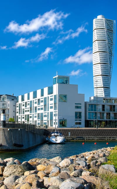 Ribersborg waterfront in Malmö, the twisting Turning Torso tower rising above modern seaside apartments and a small marina