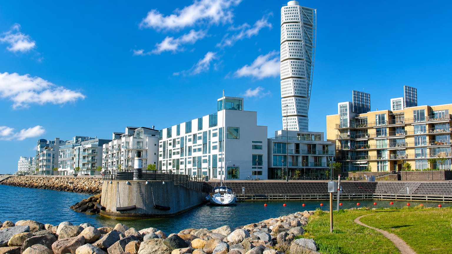 Ribersborg waterfront in Malmö, the twisting Turning Torso tower rising above modern seaside apartments and a small marina