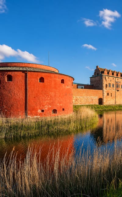 Malmöhus Castle's red round bastion reflected in its moat, Västra Innerstaden, Malmö, Sweden