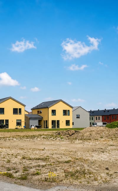 Colourful new-build houses beside a cleared building plot in a Staffanstorp housing area, Sweden.