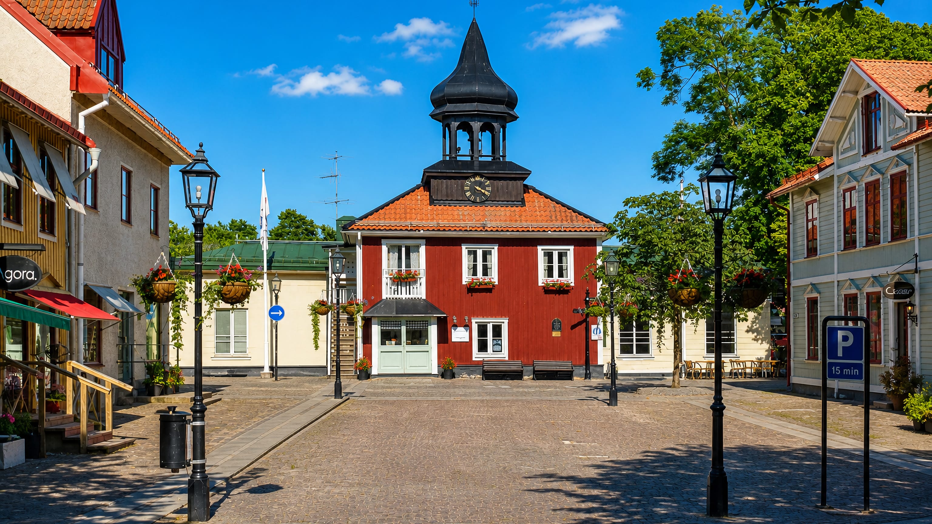 Trosa's red timber town hall with its black onion-domed bell tower rising over the cobbled main square, Sweden.