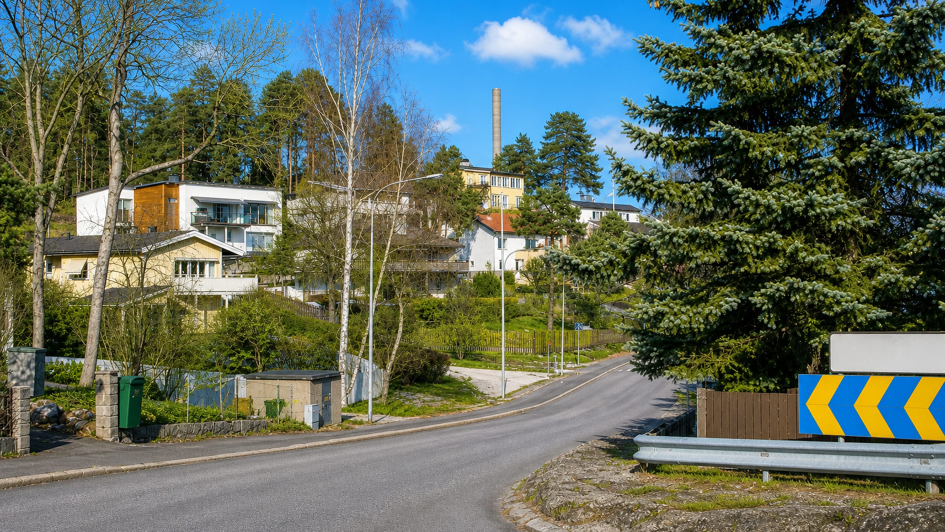 Villas on a rocky wooded slope above a curving residential road in Käppala, Lidingö.