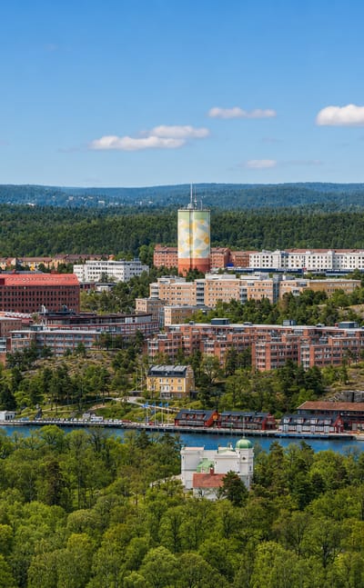 Nacka skyline in Sweden with apartment blocks, the painted water tower and Nacka Forum mall above the water.