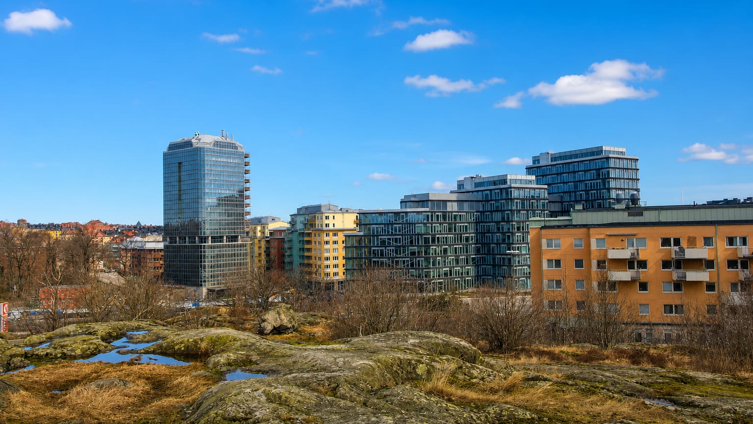 Modern glass office tower and apartment blocks above rocky bedrock terrain in Skytteholm, Solna, Sweden