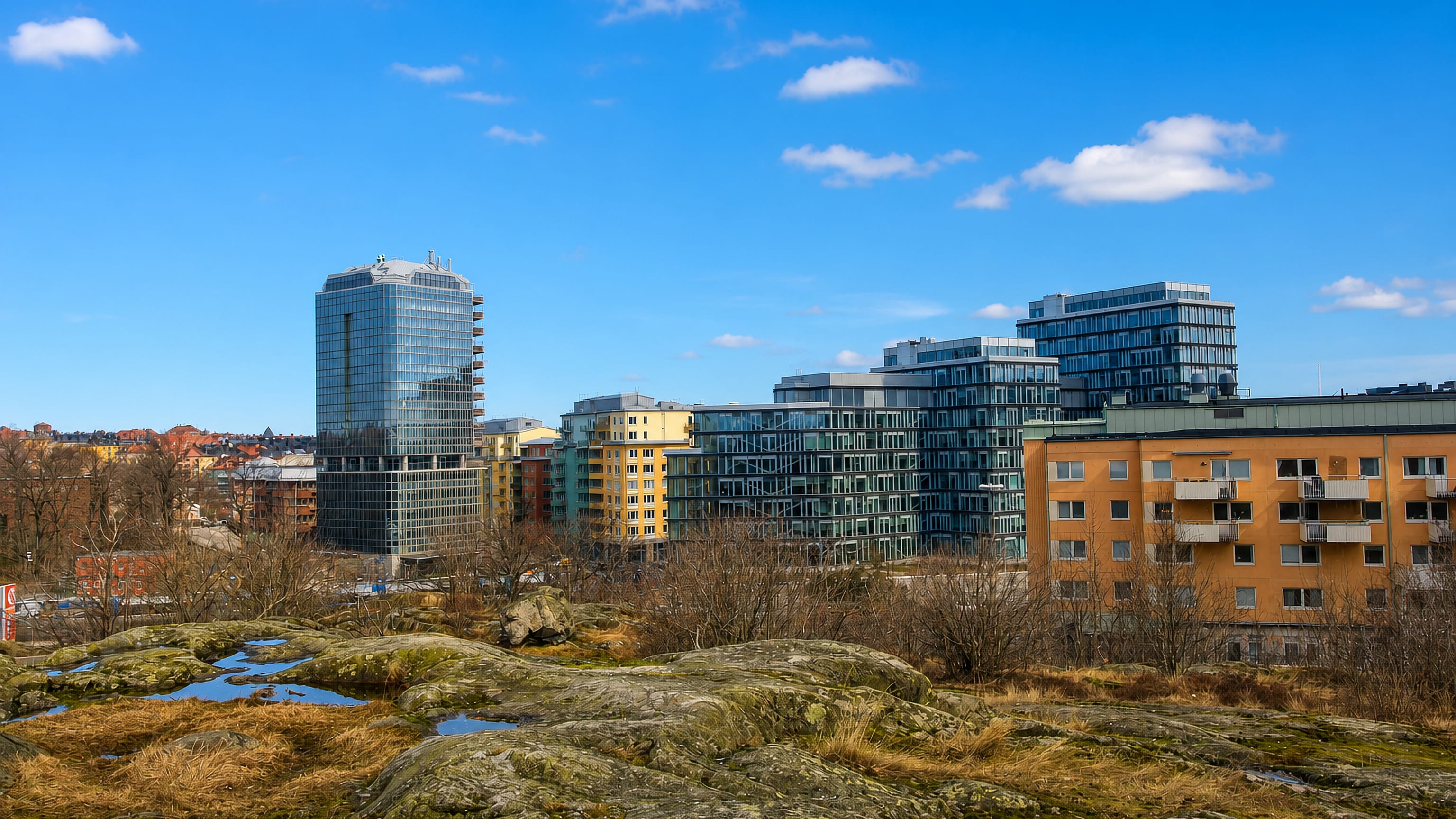Modern glass office tower and apartment blocks above rocky bedrock terrain in Skytteholm, Solna, Sweden