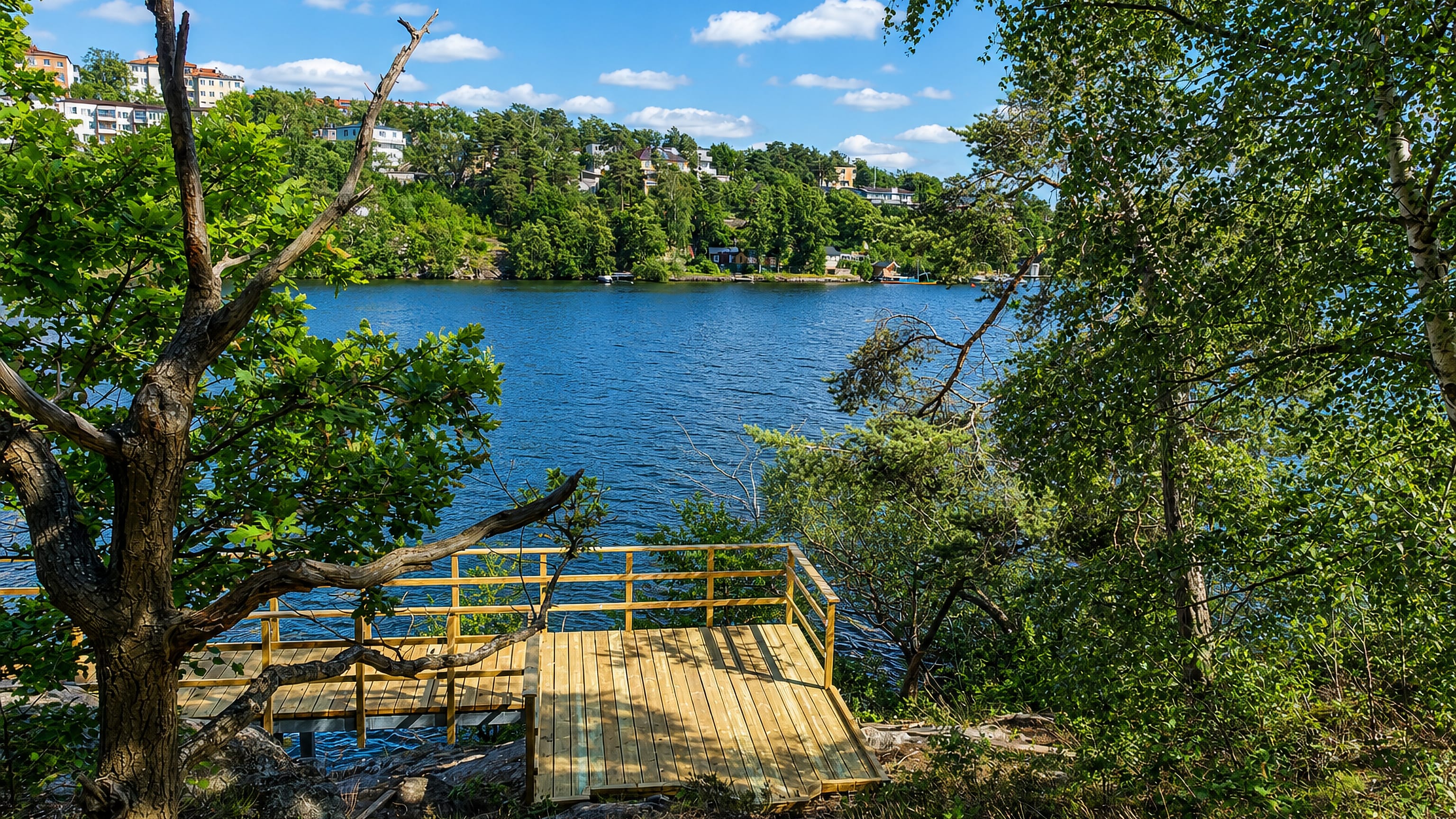 Wooden jetty on a wooded bay lined with villas at Äppelviken in western Stockholm.