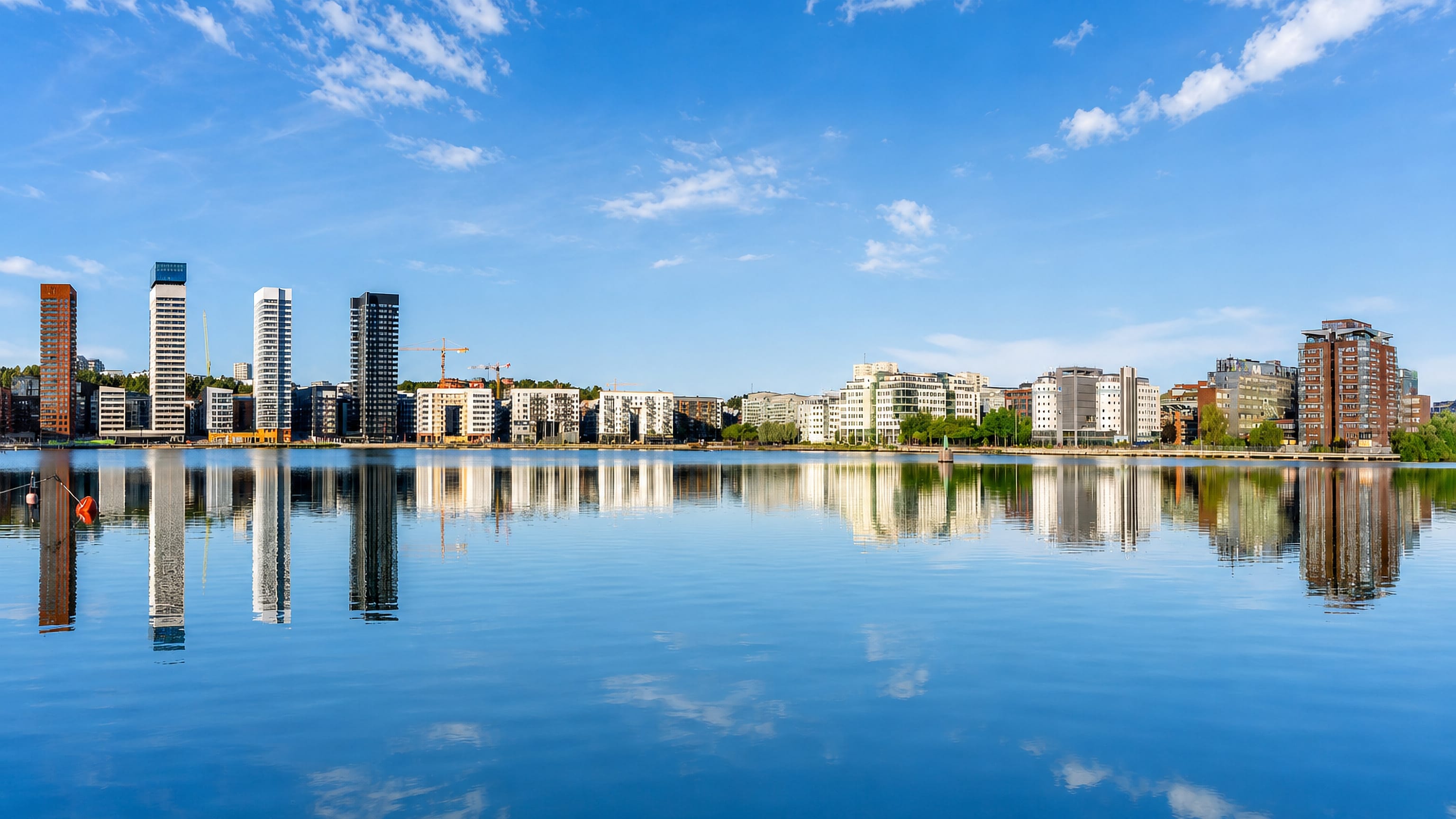 Liljeholmskajen's waterfront towers mirrored in the still water of Årstaviken, Liljeholmen, Stockholm.