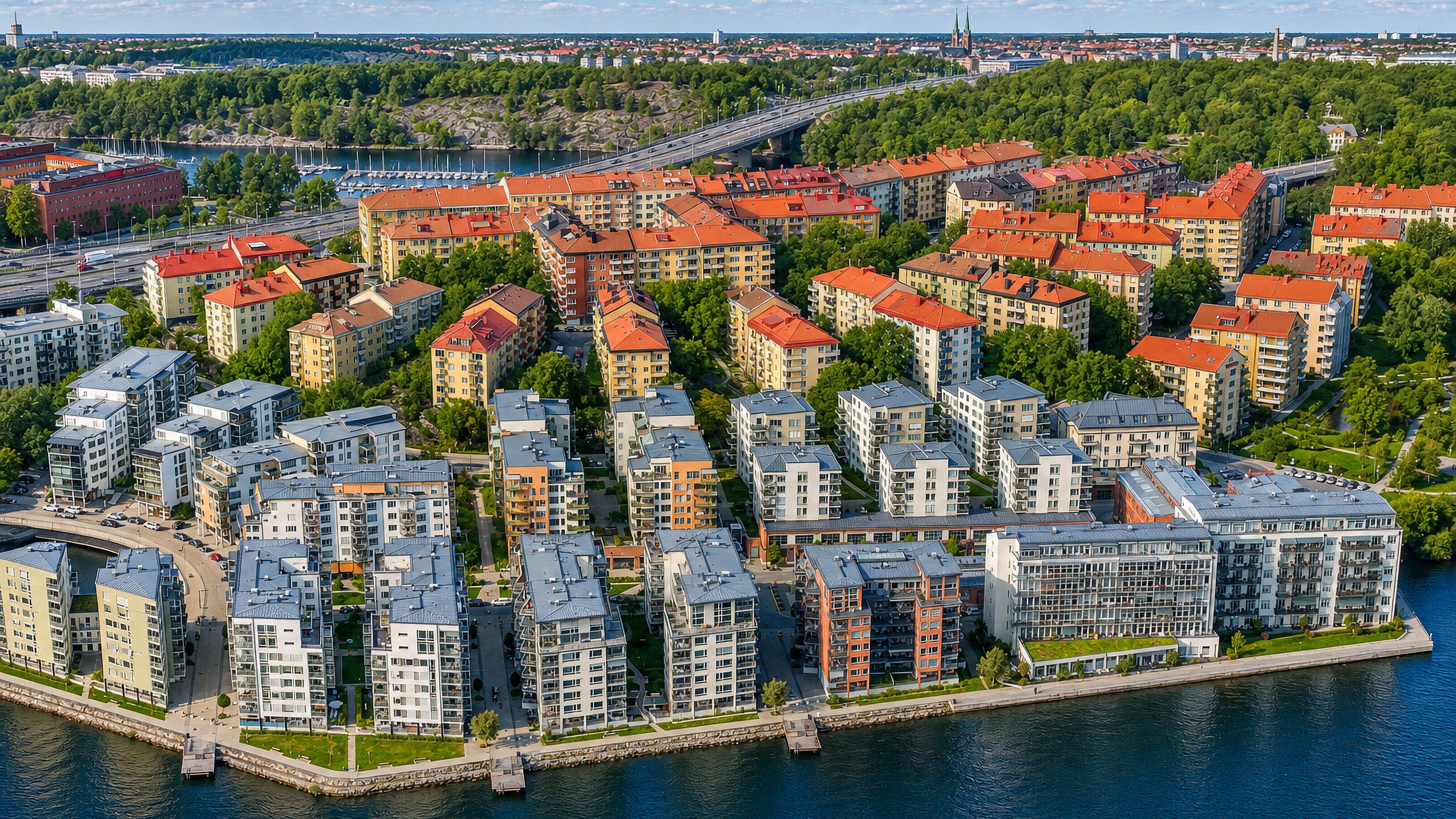 Aerial view of Lilla Essingen island in Stockholm, waterfront apartment blocks and marina with the city skyline beyond.