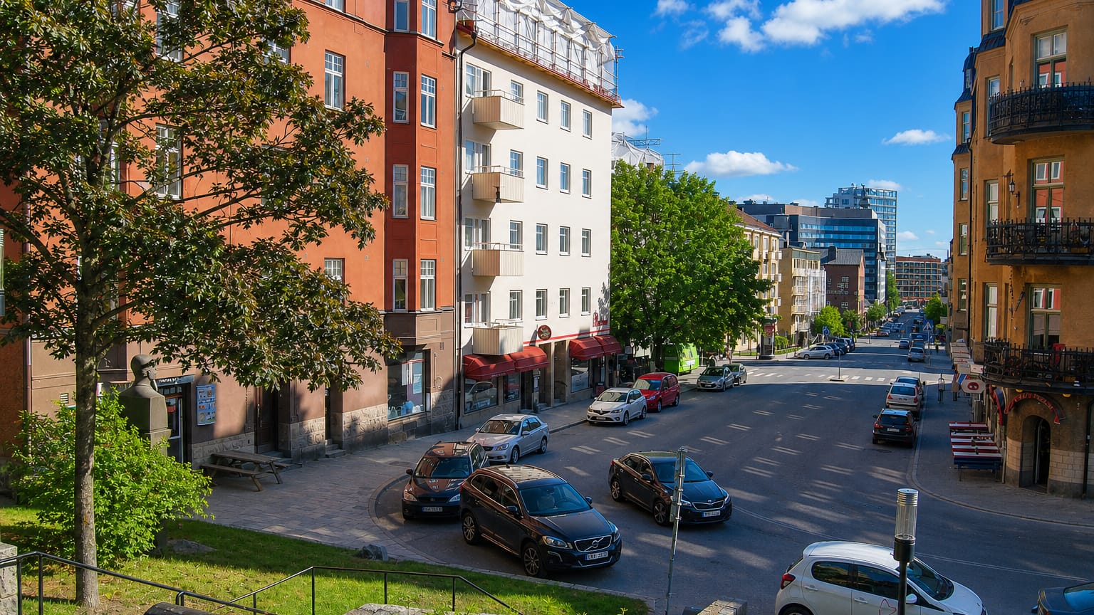 Sundbyberg street lined with red and ochre apartment blocks, parked cars and distant glass towers