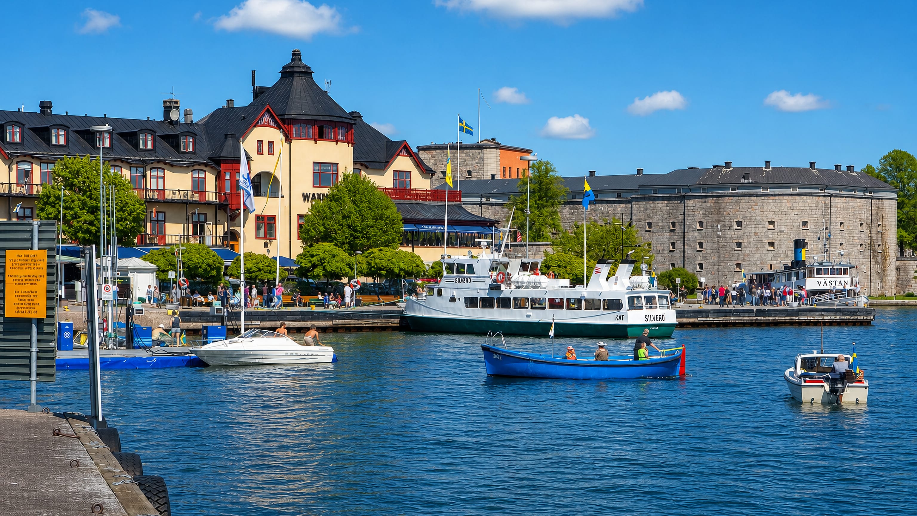 Vaxholm waterfront with the Waxholms Hotell, the round Vaxholm Fortress tower and a passenger ferry at the quay
