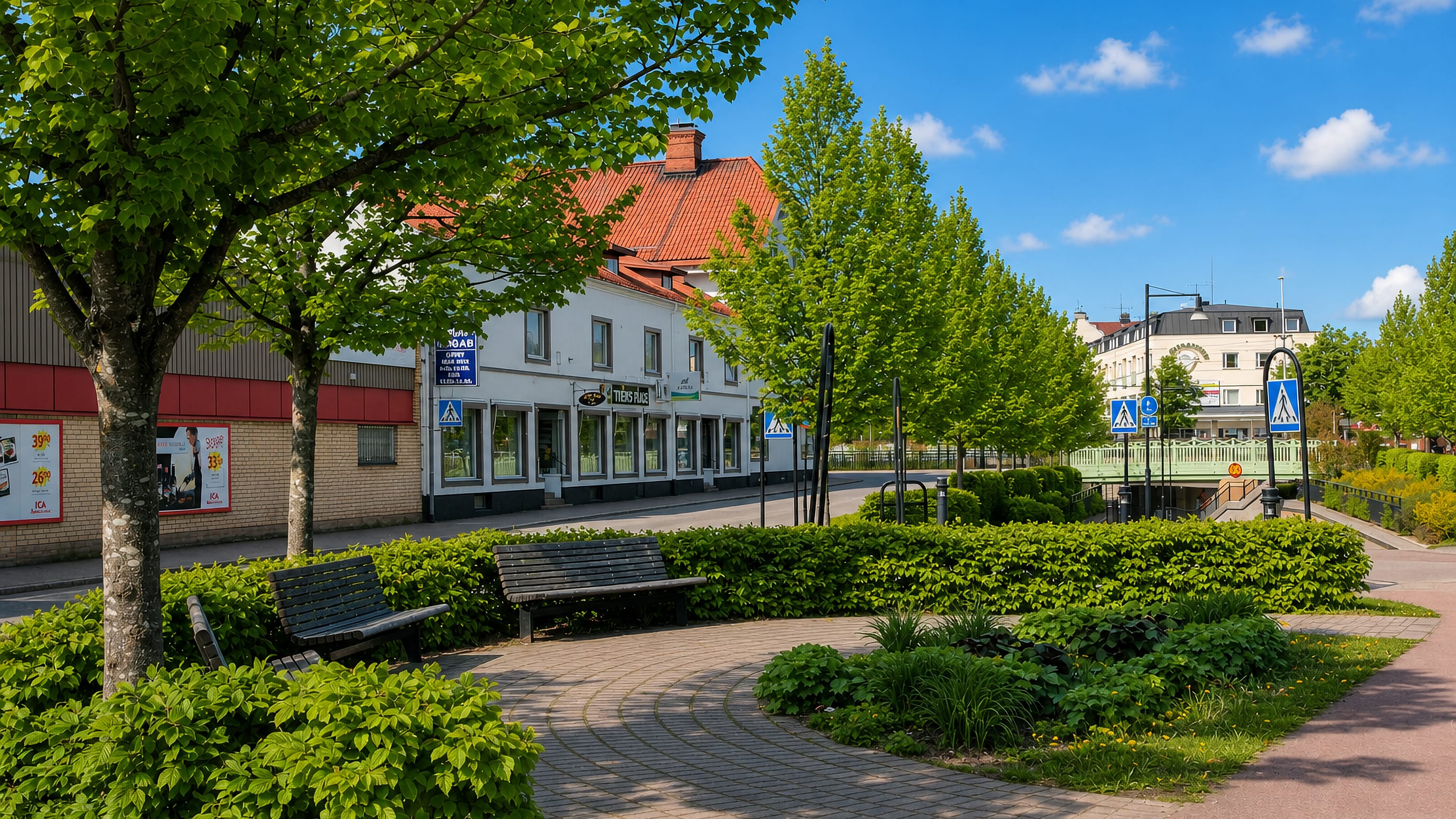 Landscaped pedestrian square with benches and shopfronts lining a quiet street in central Tierp, Sweden.