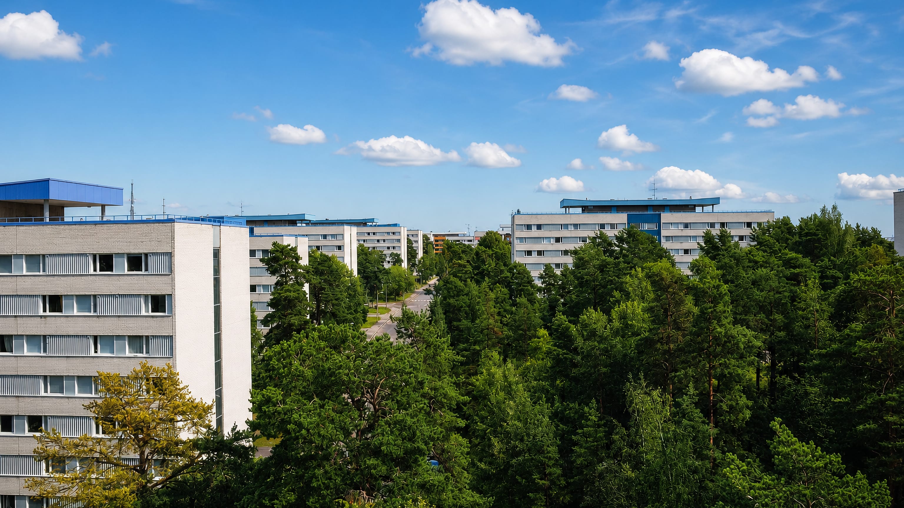 White high-rise student housing blocks of Flogsta rising above pine forest in Uppsala, Sweden